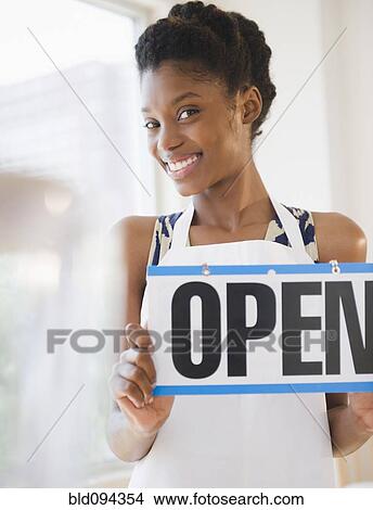 Black business owner holding open sign View Large Photo Image Picture - Black business owner holding open sign. Fotosearch
