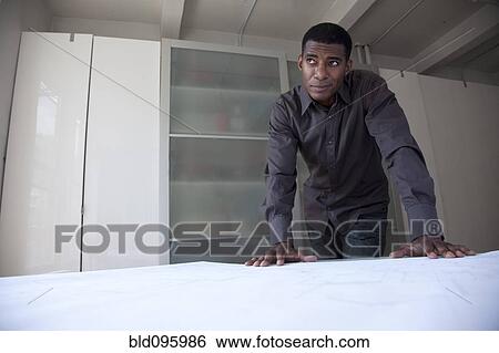 Black businessman reviewing blueprints View Large Photo Image Stock Photograph - Black businessman reviewing blueprints. Fotosearch