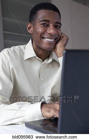 Black businessman typing on laptop View Large Photo Image Stock Image - Black businessman typing on laptop. Fotosearch