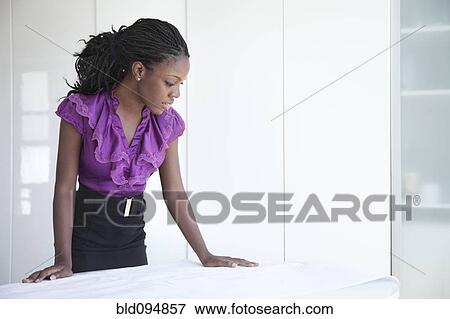 Stock Photo - Black businesswoman reviewing blueprints. Fotosearch
