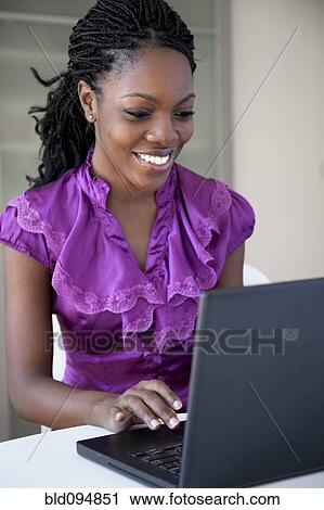 Stock Image - Black businesswoman typing on laptop. Fotosearch