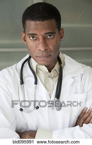 Stock Image - Black doctor in lab coat with arms crossed. Fotosearch