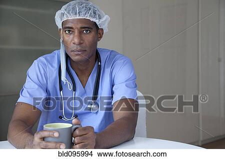 Picture - Black doctor in scrubs and surgical cap. Fotosearch