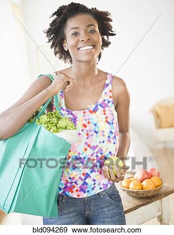Black woman carrying reusable grocery bag View Large Photo Image Stock Photo - Black woman carrying reusable grocery bag. Fotosearch