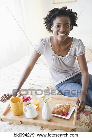 Stock Photo - Black woman having breakfast in bed. Fotosearch