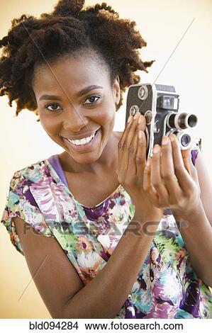 Black woman holding old-fashioned video camera View Large Photo Image Picture - Black woman holding old-fashioned video camera. Fotosearch