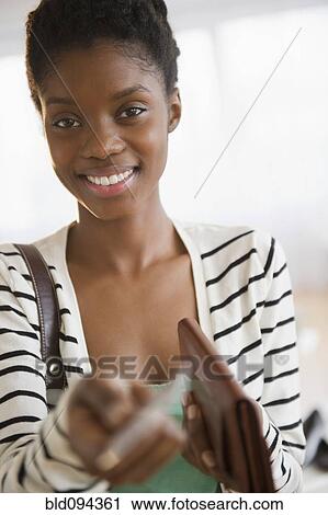 Stock Image - Black woman holding out credit card. Fotosearch
