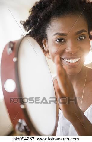 Black woman holding tambourine View Large Photo Image Stock Photo - Black woman holding tambourine. Fotosearch