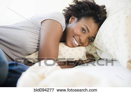 Stock Photo - Black woman laying in bed. Fotosearch