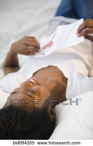 Black woman laying on bed reading Valentine's Day card View Large Photo Image Stock Photography - Black woman laying on bed reading Valentine's Day card. Fotosearch
