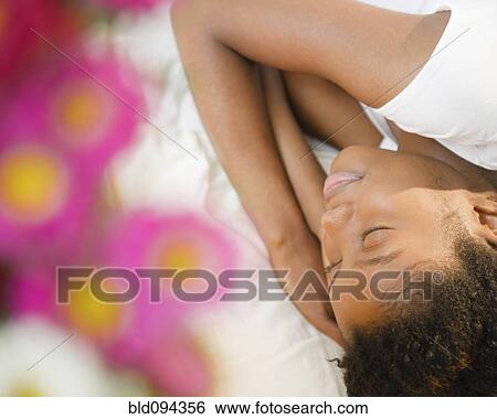 Stock Photograph - Black woman sleeping on bed. Fotosearch