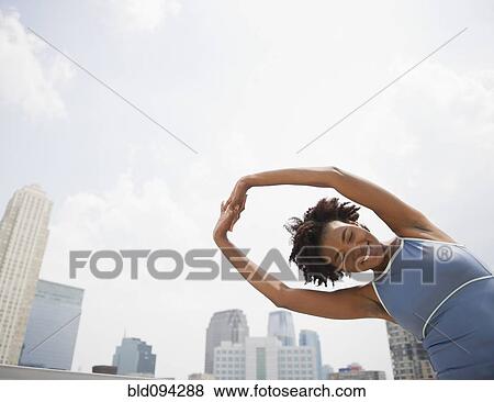 Stock Photo - Black woman stretching before exercise. Fotosearch