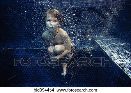 Boy swimming underwater in swimming pool View Large Photo Image Picture - Boy swimming underwater in swimming pool. Fotosearch