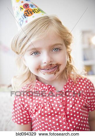 Stock Photo - Caucasian girl at birthday party with chocolate on her face. Fotosearch