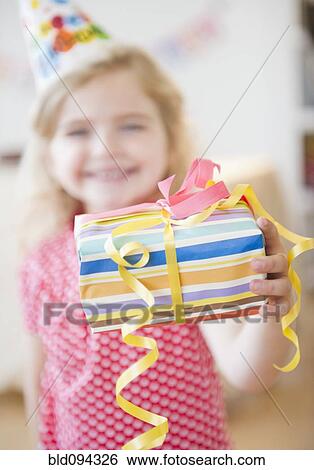 Stock Photograph - Caucasian girl holding birthday gift. Fotosearch