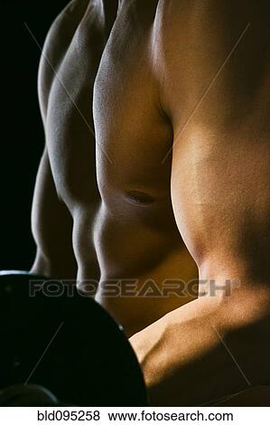 Stock Photo - Caucasian man exercising with barbells. Fotosearch