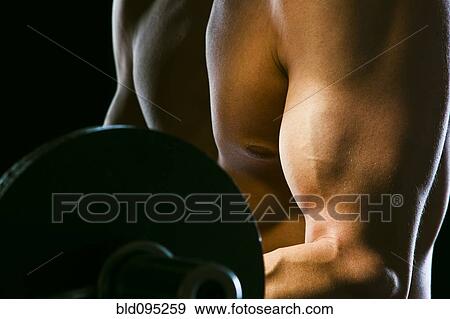 Stock Photo - Caucasian man exercising with barbells. Fotosearch