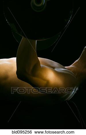 Stock Photograph - Caucasian man exercising with barbells. Fotosearch