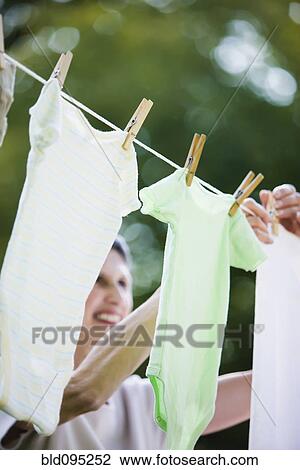 Caucasian woman hanging laundry on clothes line View Large Photo Image Stock Image - Caucasian woman hanging laundry on clothes line. Fotosearch
