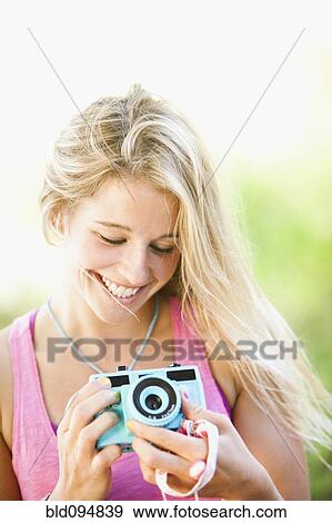 Stock Photo - Caucasian woman holding camera. Fotosearch