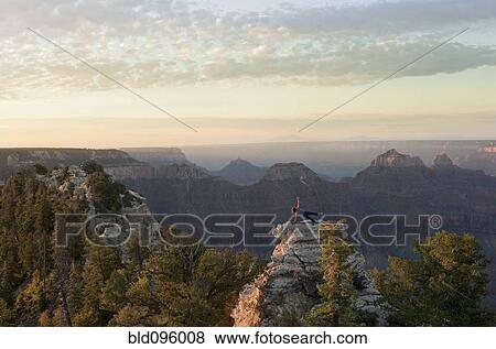 Stock Photo - Caucasian woman practicing yoga on top of rock formation. Fotosearch