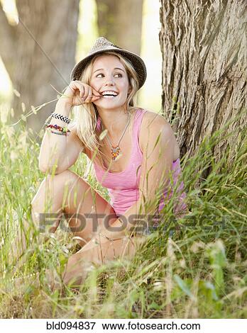 Stock Photo - Caucasian woman sitting in grass. Fotosearch