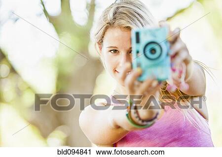 Stock Image - Caucasian woman taking photographs. Fotosearch