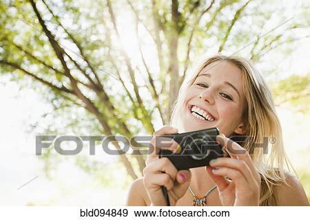 Stock Photo - Caucasian woman taking photographs. Fotosearch