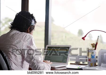 Stock Image - Caucasian woman typing on laptop. Fotosearch