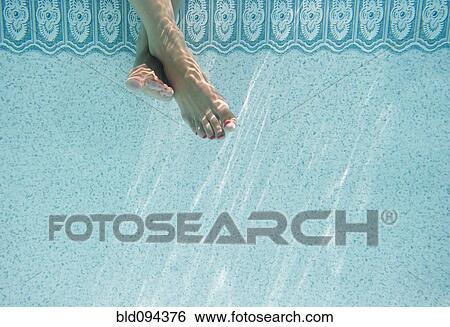 Stock Photograph - Caucasian woman's feet underwater in swimming pool. Fotosearch