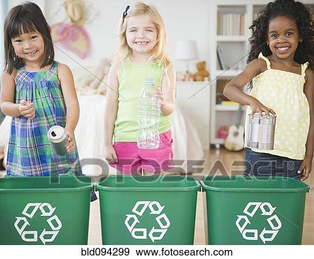 Stock Photo - Children putting recyclable materials into recycling bins. Fotosearch