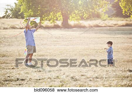 Stock Photo - Chinese grandfather and grandson flying kite. Fotosearch