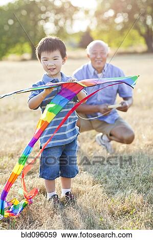 Stock Photo - Chinese grandfather and grandson flying kite. Fotosearch