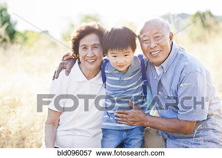 Stock Photo - Chinese grandparents in field with grandson. Fotosearch
