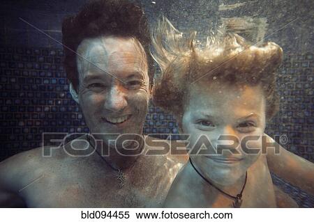 Stock Photography - Father and son swimming underwater in swimming pool. Fotosearch