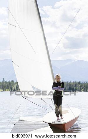 Girl standing on sailboat moored at dock View Large Photo Image Stock Image - Girl standing on sailboat moored at dock. Fotosearch