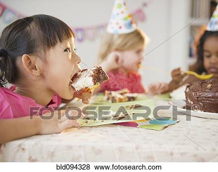 Girls enjoying cake at birthday party View Large Photo Image Stock Photo - Girls enjoying cake at birthday party. Fotosearch