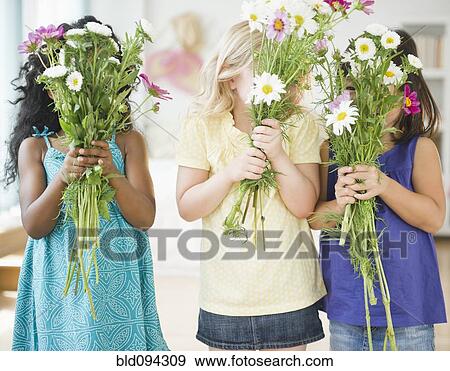 Stock Photo - Girls holding bouquets of flowers. Fotosearch