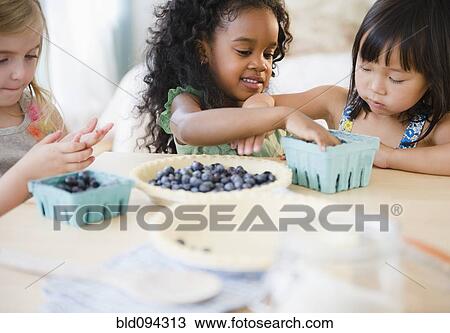 Girls putting blueberries into bowl together View Large Photo Image Stock Image - Girls putting blueberries into bowl together. Fotosearch