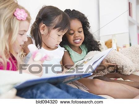 Girls reading book together View Large Photo Image Stock Image - Girls reading book together. Fotosearch