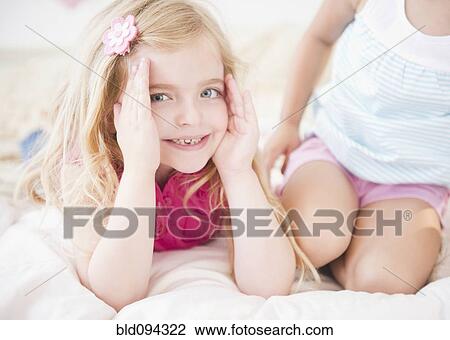 Girls sitting on bed together View Large Photo Image Stock Image - Girls sitting on bed together. Fotosearch