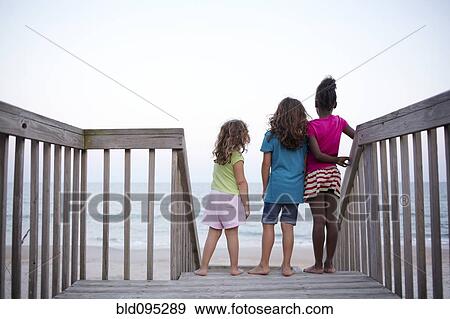 Girls standing together on deck near ocean View Large Photo Image Stock Photo - Girls standing together on deck near ocean. Fotosearch