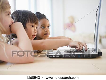 Girls using laptop together View Large Photo Image Picture - Girls using laptop together. Fotosearch