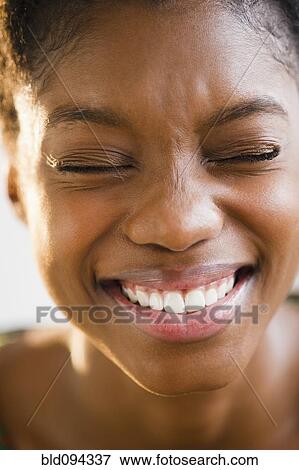 Grinning Black woman with eyes closed View Large Photo Image Stock Photo - Grinning Black woman with eyes closed. Fotosearch