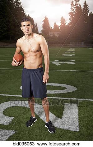 Hispanic athlete holding football View Large Photo Image Stock Image - Hispanic athlete holding football. Fotosearch
