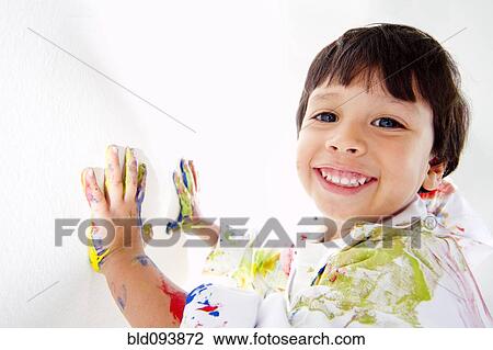 Stock Image - Hispanic boy finger painting. Fotosearch