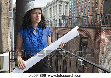 Hispanic businesswoman holding blueprints View Large Photo Image Stock Photograph - Hispanic businesswoman holding blueprints. Fotosearch