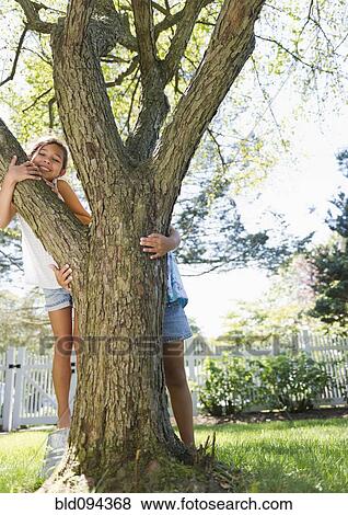 Stock Photo - Hispanic children playing near tree. Fotosearch