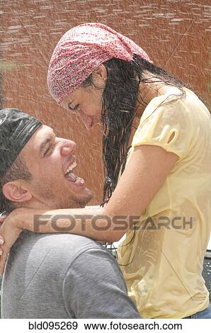 Stock Photo - Hispanic couple getting squirted with water. Fotosearch