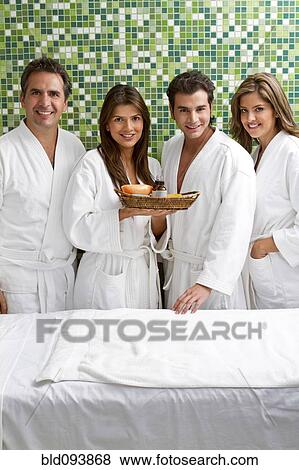 Stock Photo - Hispanic couples wearing bathrobes in spa. Fotosearch